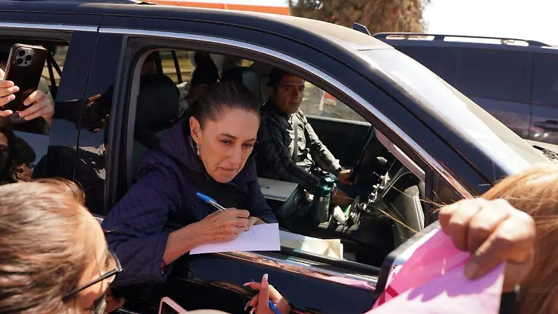 Claudia Sheinbaum firmando un documento a las madres buscadoras en San Quintín